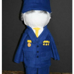Front view of a 2-liter soda bottle person school project, decorated with fabric clothes, a polar fleece hat, and painted Poly-Fil hair.