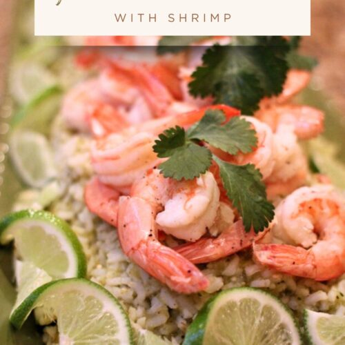 Green chile rice topped with shrimp, lime slices, and cilantro on a white plate, served as a colorful, easy dinner.