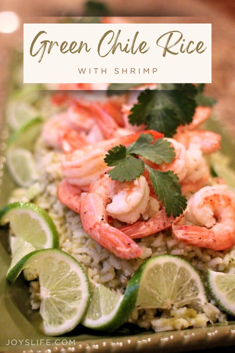 Green chile rice topped with shrimp, lime slices, and cilantro on a white plate, served as a colorful, easy dinner.