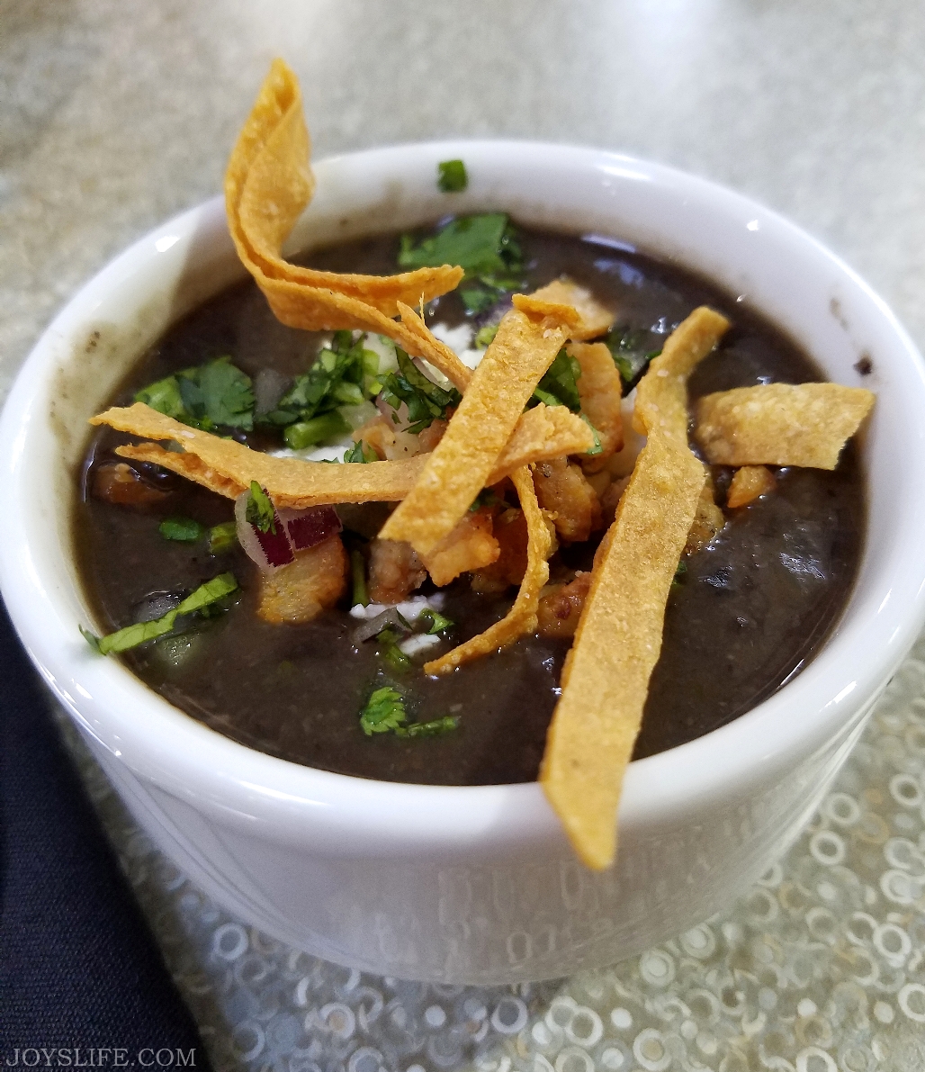 Black bean soup topped with farmer’s cheese, red onions, cilantro and crispy pork