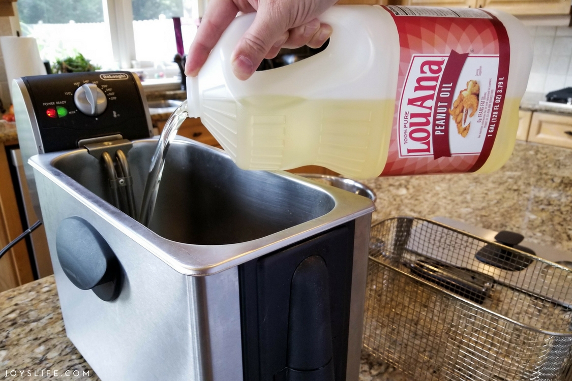 Pouring LouAna Peanut Oil into deep fryer