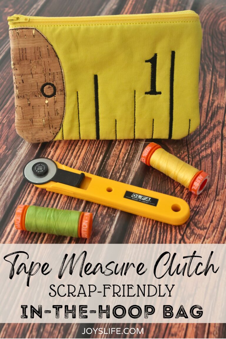 Yellow Tape Measure Clutch embroidery bag with cork fabric end, shown with rotary cutter and thread on a wooden surface.