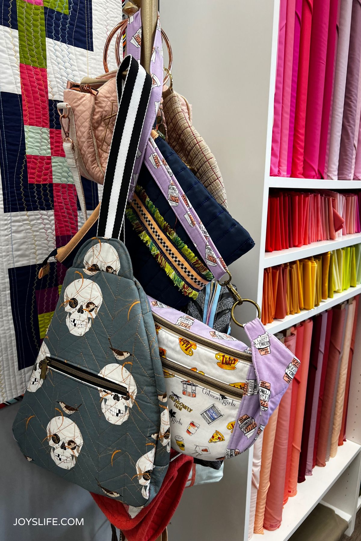 Quilted bags and rainbow fabric shelves on display at Bernina of Naperville quilt shop.