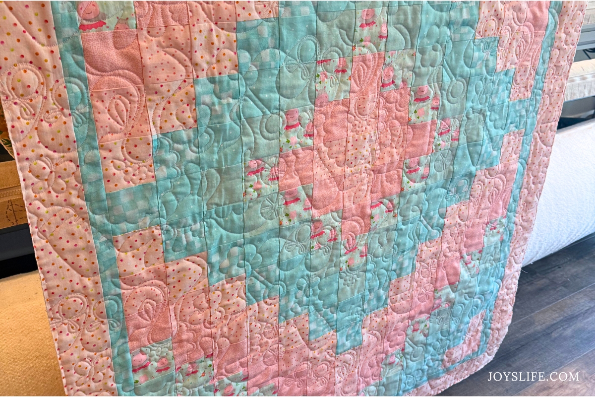 Baby girl quilt with tiny hippo fabric and pastel chevron pattern longarm quilted by Joy on a Bernina Q24 at joyslife.com