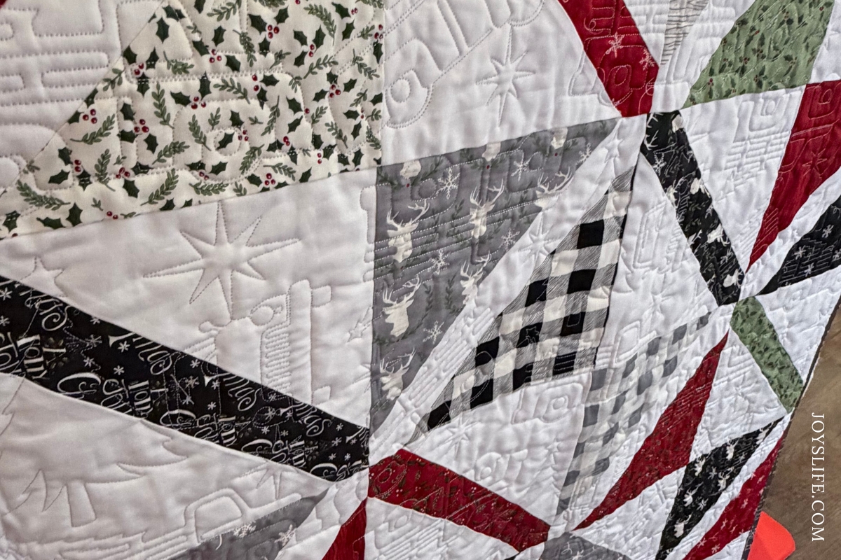 Christmas geometric farmhouse style quilt in red, green, black, and white triangle blocks, longarm quilted on a Bernina Q24 by Joy at JoysLife.com
