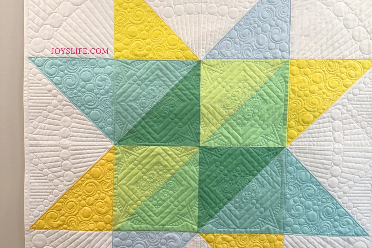 Modern star quilt in yellow, green, and teal fabrics with custom quilting, pieced and quilted by Joy at joyslife.com on a Bernina Q24 longarm